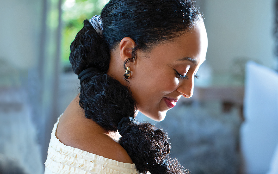 Tamera Mowry Housley smiling with hairbands in hair